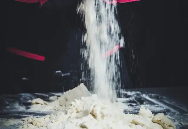 Baker mixing dough by hand for starting a bakery business