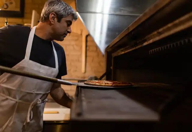 Cook baking pizza for scheduling staff in a shared kitchen