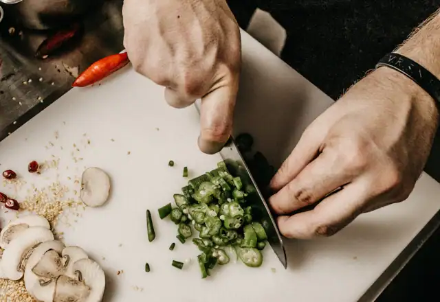 Person slicing a vegetable for scheduling staff in a shared kitchen