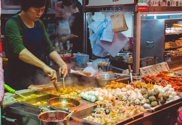 Woman cooking street food at a stall for transporting food from a rental kitchen
