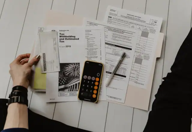 Hands with paper, pen and calculator for availability and booking