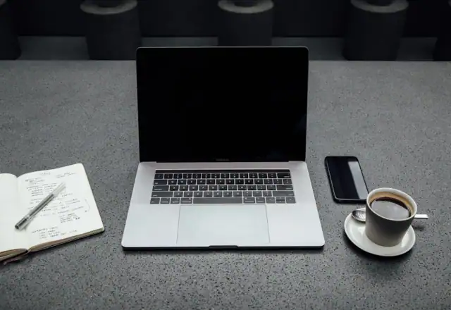 Laptop, coffee and notebook on a desk for availability and booking