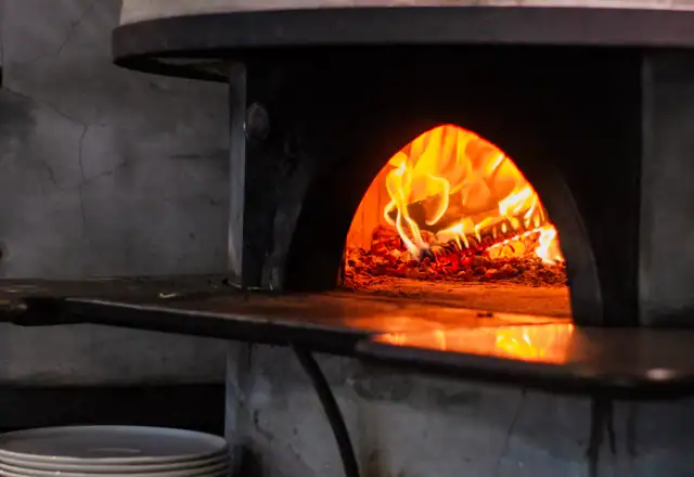 Pizza baking in a wood-fired oven for bakery kitchen