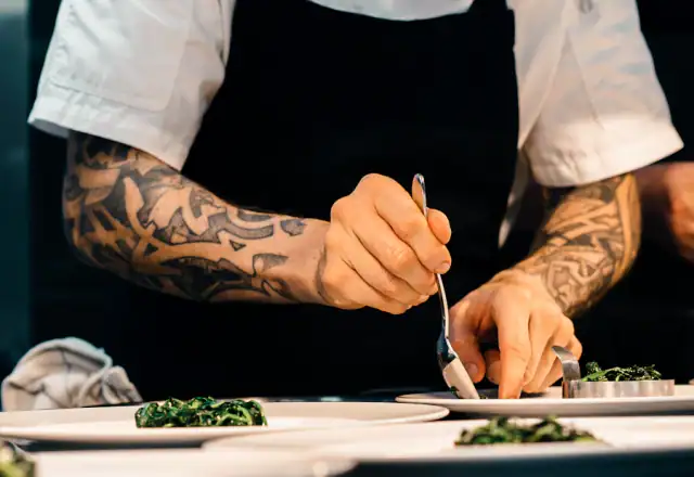 Cook placing food on a plate for shared kitchen rental