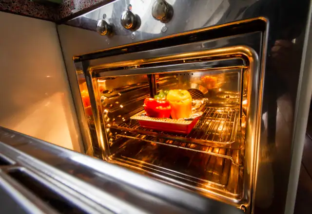 Stainless steel oven with food baking inside for questions to ask on a kitchen tour