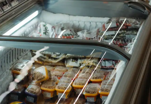 Assorted food in a silver commercial refrigerator for dishwashing and wash-up facilities