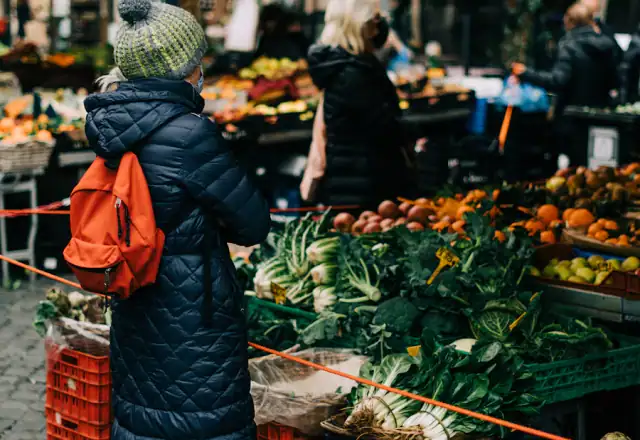 Farmers market vendor in front of fresh vegetables for commercial kitchen rental in florida