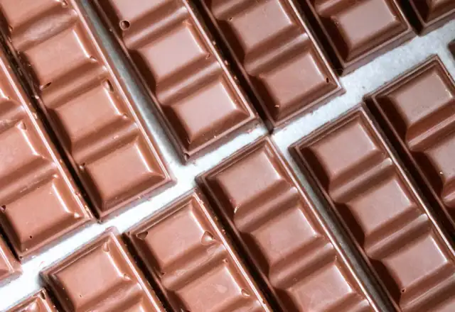 Rows of chocolate bars lined up on a table for kitchen rental for confectionery makers