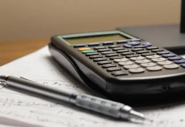 Calculator and pen on a piece of paper for planning cash flow around kitchen rental