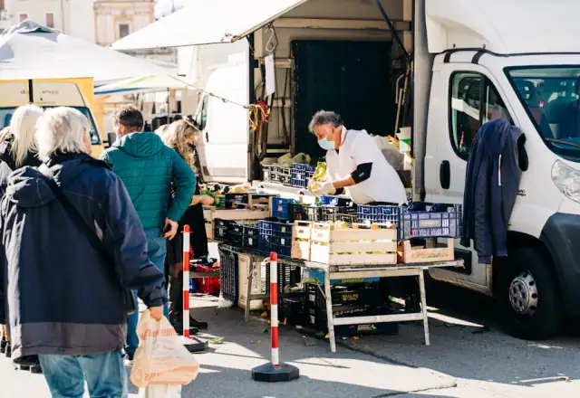 People gathered around a market stall table for commercial kitchen rental in oklahoma