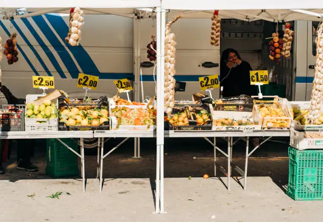 Vendor standing in front of a market table of fruit for commercial kitchen rental in delaware