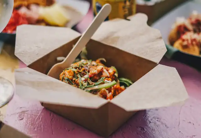 Takeout boxes of food and drinks on a table for cloud, dark and ghost kitchen rental