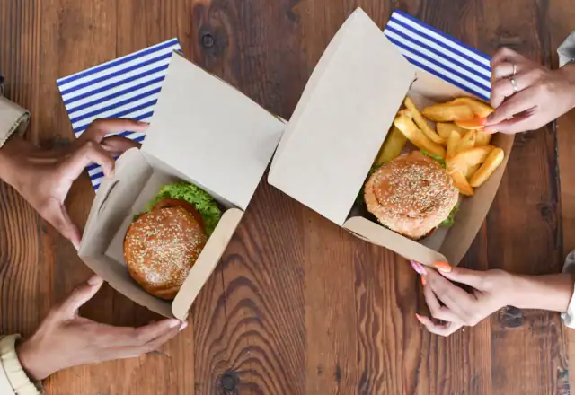 Group holding open boxes of food for about us