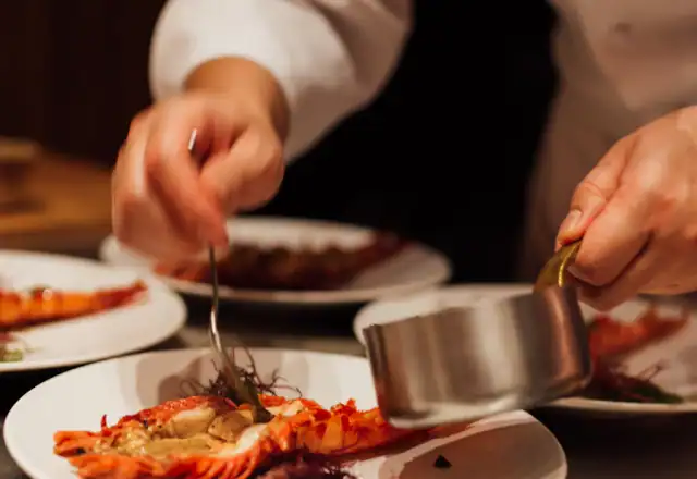 Chef in uniform preparing food on a table for kosher kitchen