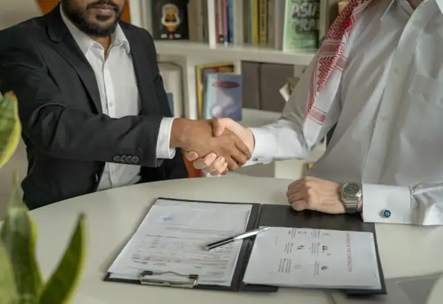 Two men shaking hands over a desk for pricing and rental plans