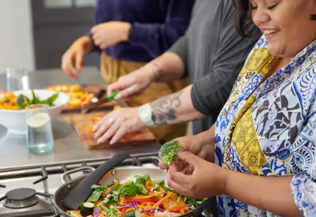 Group of women preparing food in a kitchen for teaching kitchen hire
