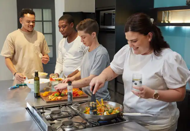 Group of people preparing food together in a kitchen for kitchen rental resource center