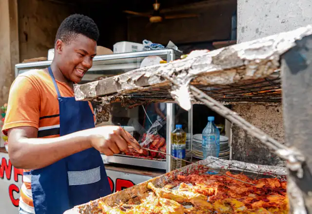 Cook in an apron grilling food at a street stall for kitchen rental states and areas