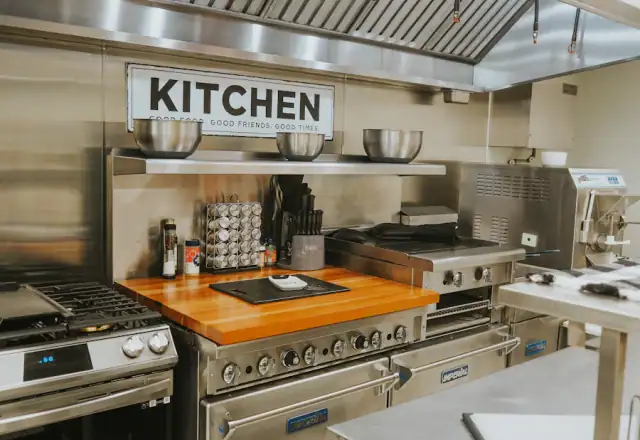 Professional kitchen with stainless steel appliances and a wooden counter for kitchen security and access