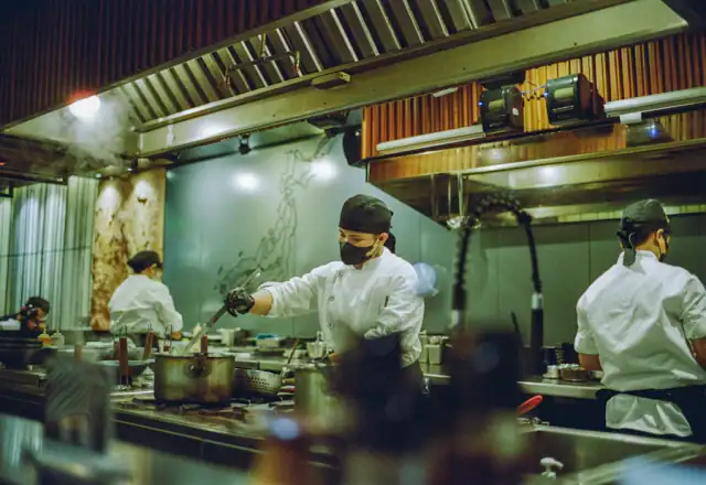 Group of chefs preparing food together in a kitchen for batch coding and product traceability