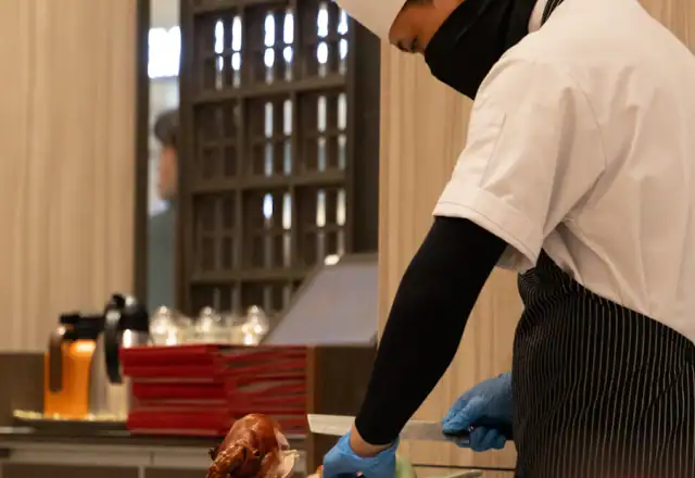 Chef carving roasted duck in a kitchen for full-time kitchen