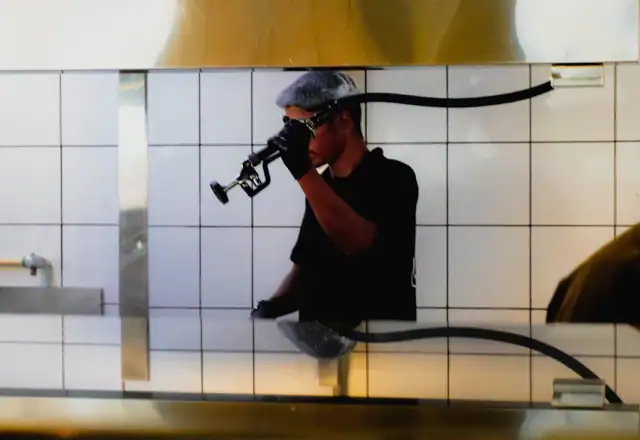 Person in gloves examining kitchen equipment for kitchen rules and hygiene
