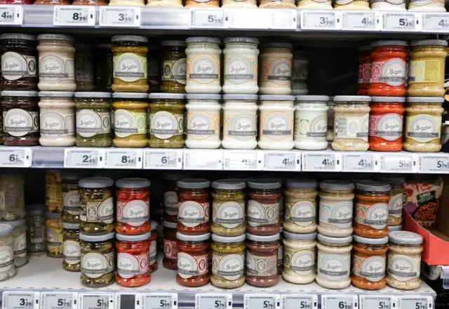 Jars of preserves and condiments on shelves for dry ingredient and packaging storage
