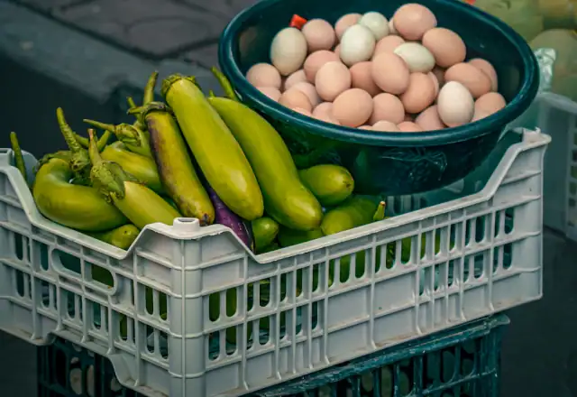 Fresh vegetables and eggs in crates at a market for kitchen rental for market vendors