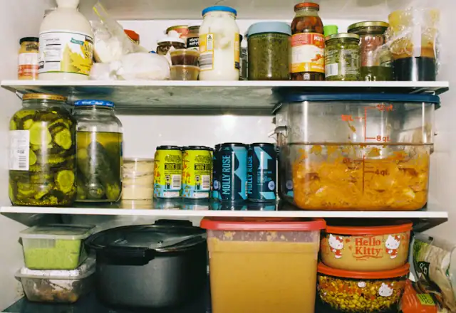 Refrigerator shelves packed with jars and food containers for refrigerated storage